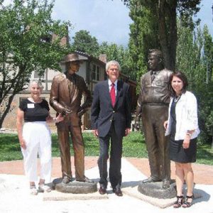 Nancy Bartlit, far left, with the bronze statues of Dr. Oppenheimer and General Leslie Groves.