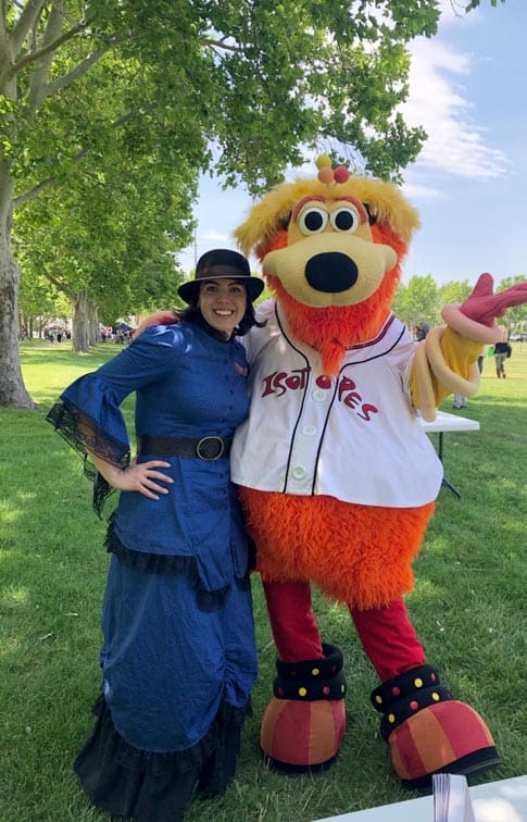 Education and Volunteer Manager Laura Gonzales is greeted by Isotopes mascot Orbit. Photo by Sharla Prather.